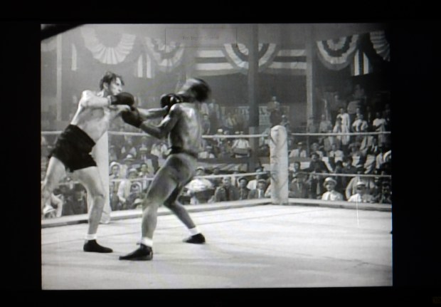 The jab in question, as Flynn delivers, snapping back the head of Ward Bond.